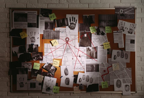 Detective board with fingerprints, photos, map and clues connected by red string