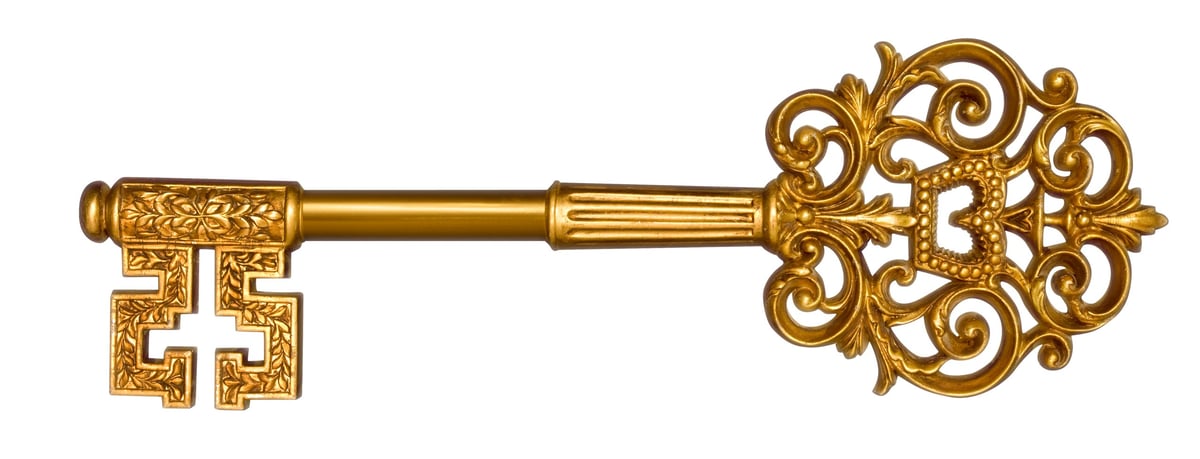 Ornate gold skeleton key with decorative cross on bow and intricate filigree head